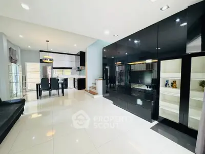 Spacious modern living room with sleek black cabinetry and open kitchen layout