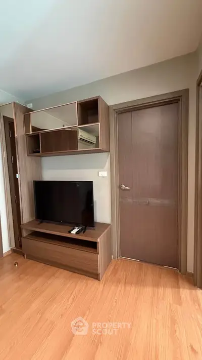 Modern living room with sleek wooden TV stand and wall-mounted shelves.