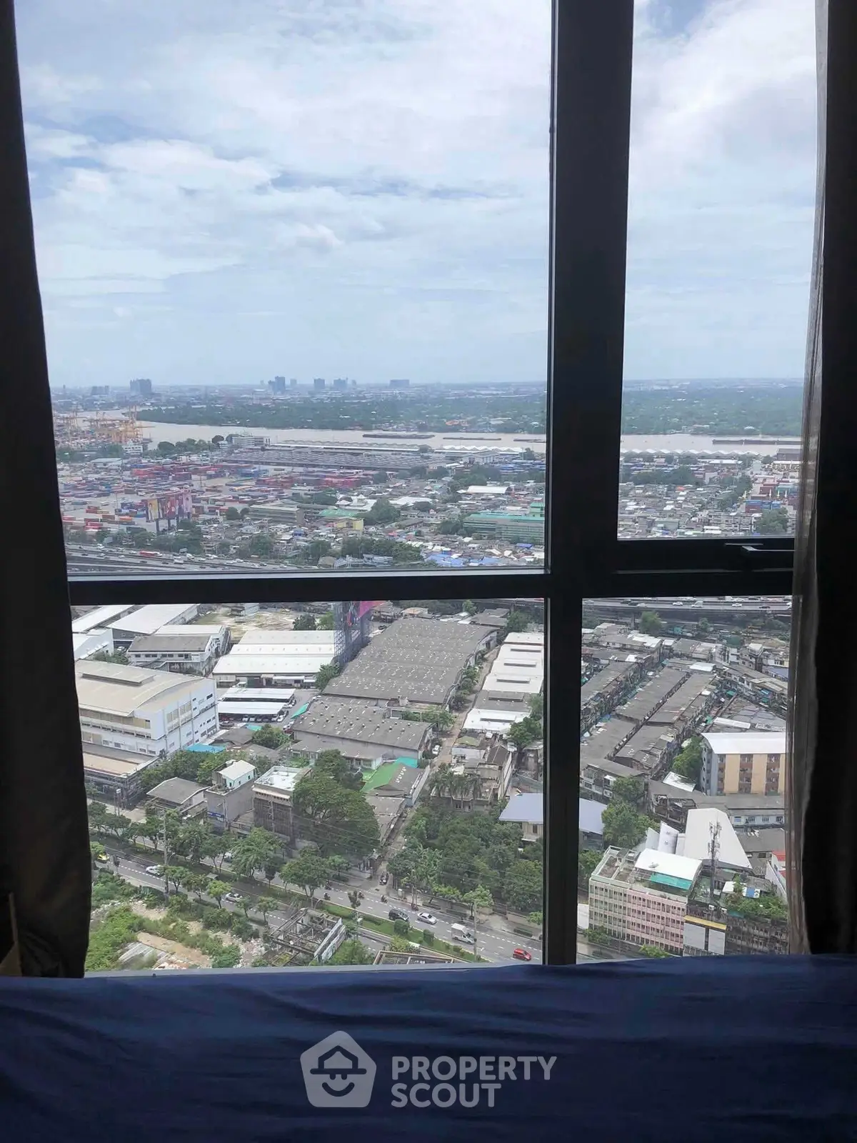 Stunning high-rise city view from a modern apartment window, showcasing urban landscape and skyline.