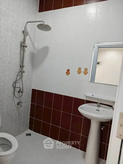 Modern bathroom with shower and pedestal sink, featuring stylish tile design.