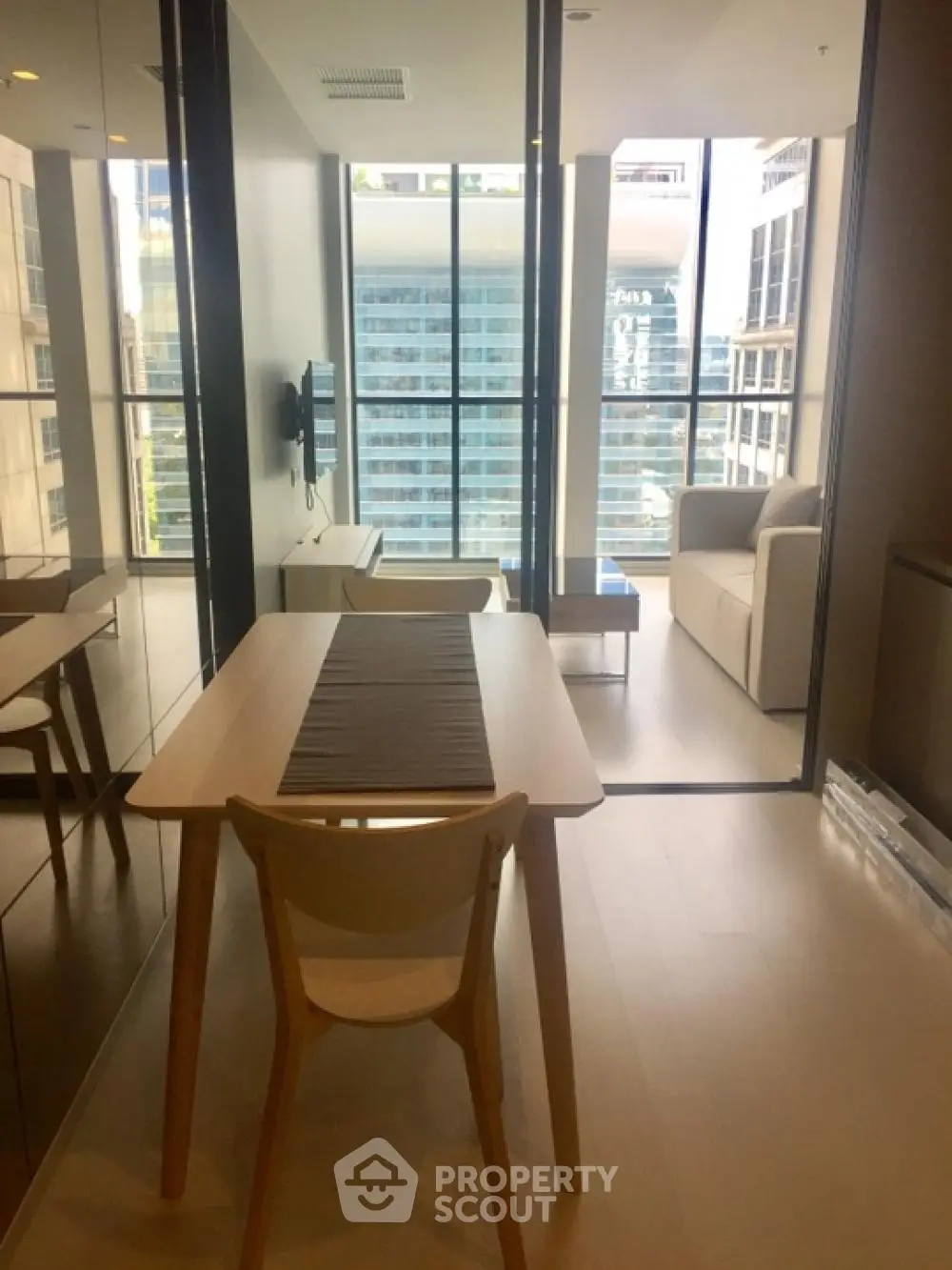 Modern apartment with open layout and city view, featuring sleek dining area and cozy living space.