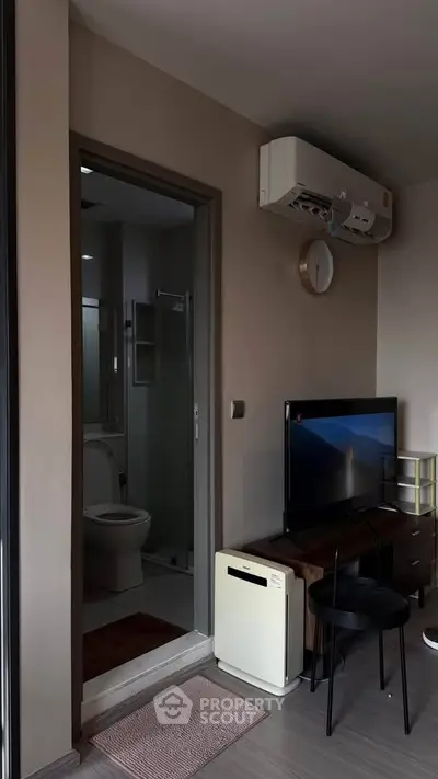 Modern apartment interior with bathroom view, featuring air conditioning and sleek furniture.