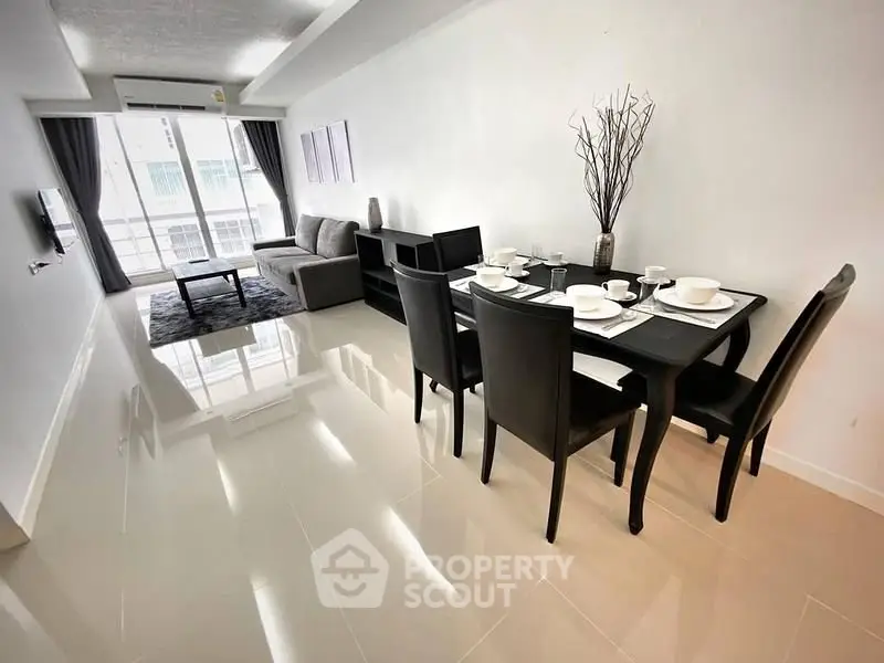 Modern living room with dining area, sleek furniture, and bright natural light.
