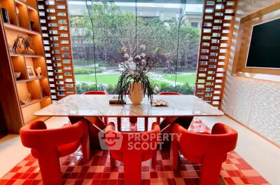 Luxurious dining area with vibrant red chairs and garden view, perfect for elegant gatherings.