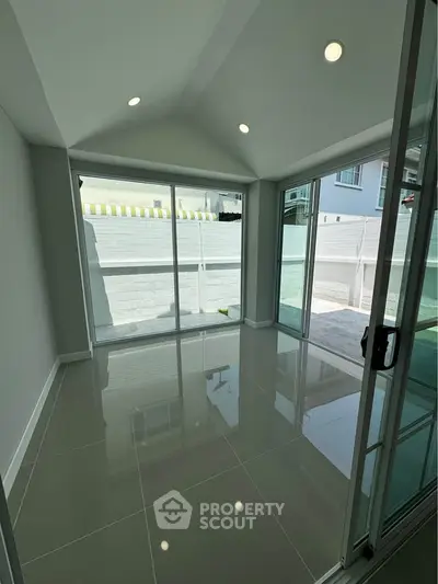 Bright sunlit room with large glass doors opening to a private patio, perfect for modern living.