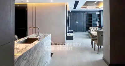 Luxurious open-plan living area with marble kitchen island and elegant dining space.