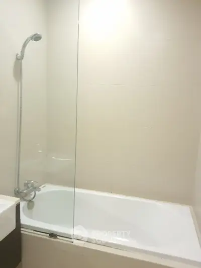 Modern bathroom with sleek bathtub and glass shower partition