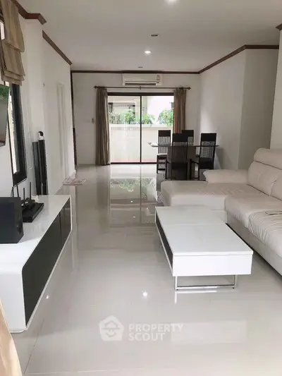Spacious modern living room with sleek white furniture and glossy floors