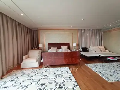 Luxurious bedroom with elegant decor and spacious layout, featuring plush seating and stylish rugs.