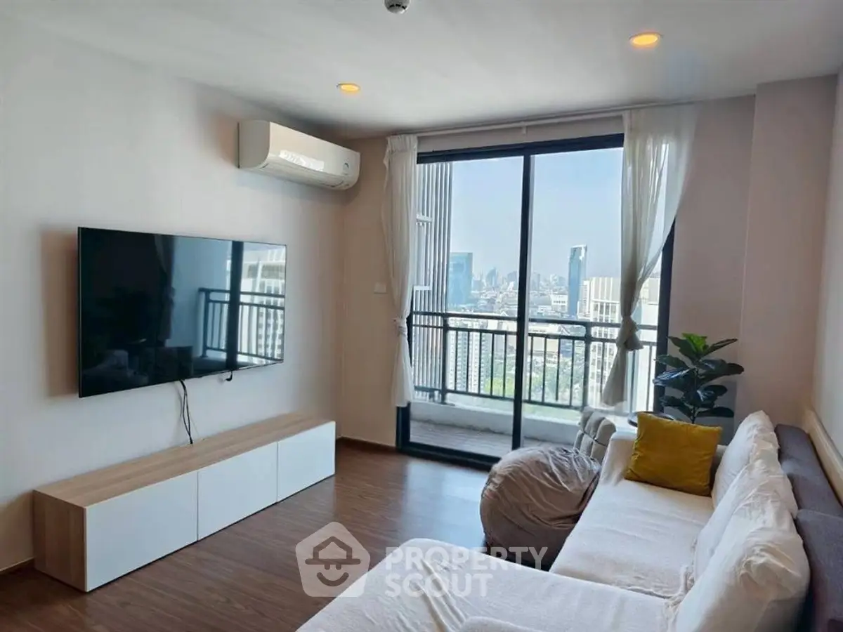 Modern living room with city view, featuring sleek furniture and large TV, perfect for urban living.
