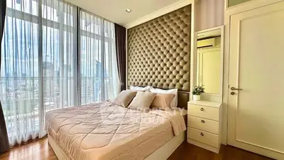 Luxurious bedroom with plush headboard and city view, perfect for urban living.