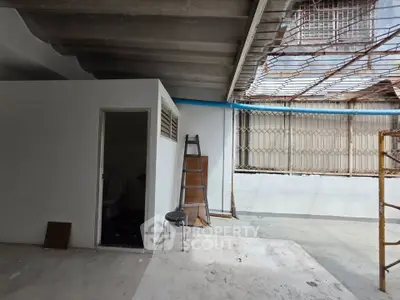 Spacious industrial-style space with high ceilings and natural light, ideal for creative projects or storage.