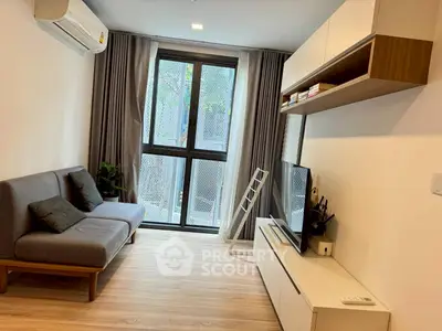 Modern living room with sleek furniture and large window for natural light.