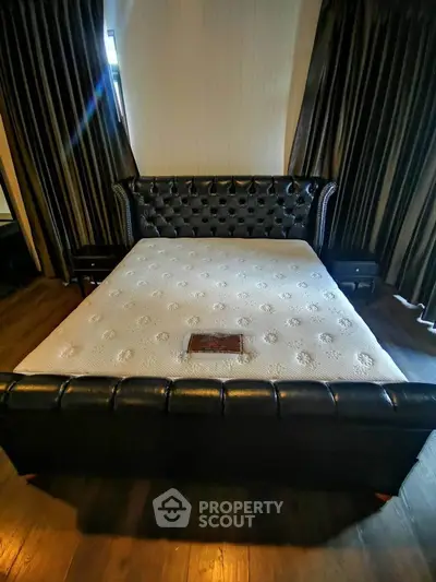 Luxurious bedroom with elegant leather bed and dark curtains