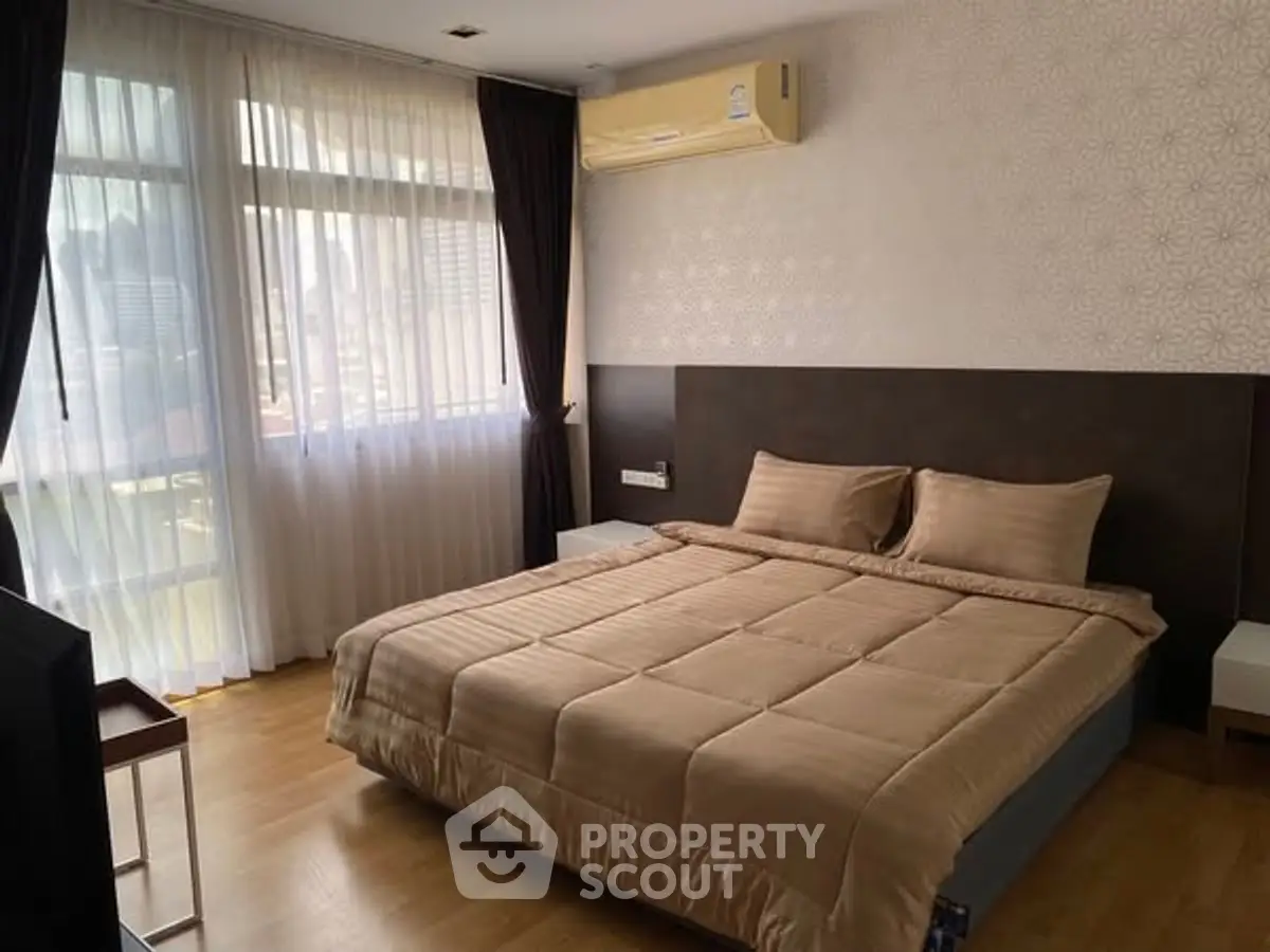 Spacious bedroom with large windows and modern decor