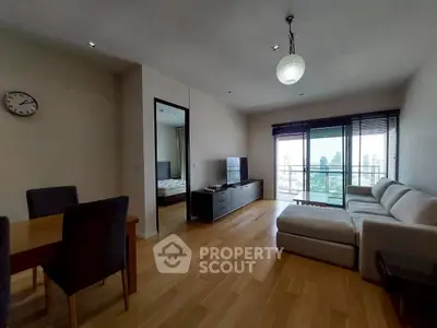 Spacious living room with modern decor and city view balcony in a high-rise apartment.