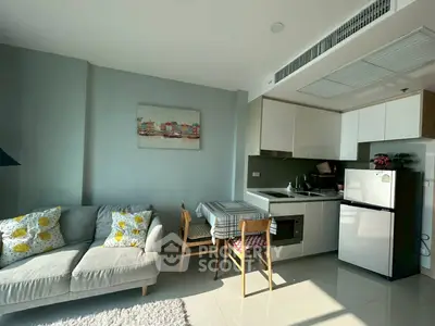 Modern open-plan living room and kitchen with cozy decor and natural light.