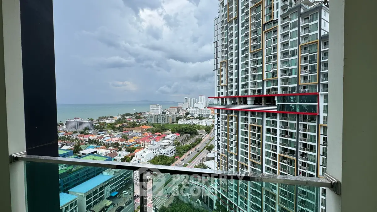 Stunning high-rise balcony view overlooking cityscape and ocean horizon.