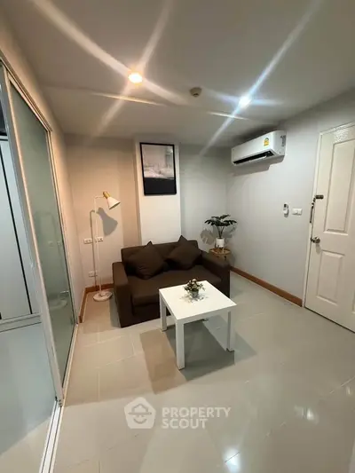 Cozy living room with modern decor and air conditioning, perfect for relaxation.