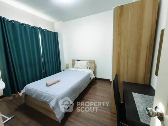 Cozy bedroom with single bed, study desk, and wooden flooring