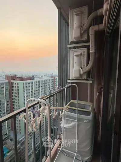 High-rise balcony with washing machine and city view at sunset