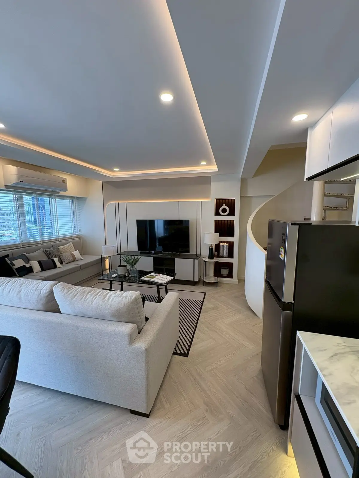 Modern living room with stylish decor and open layout, featuring a cozy sofa and sleek entertainment center.