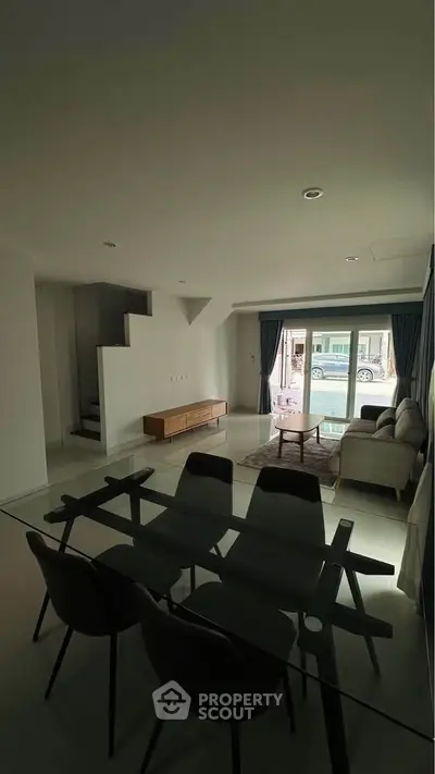 Modern living room with glass dining table and cozy seating area