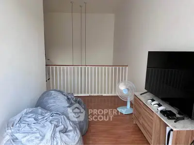 Cozy living room with bean bags and modern TV setup, perfect for relaxation.