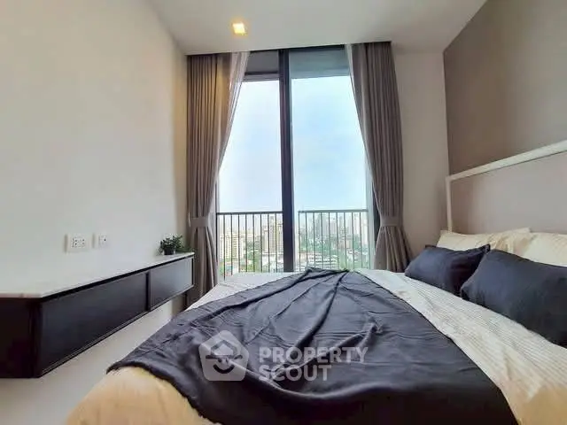 Modern bedroom with large window offering stunning city view and elegant decor.