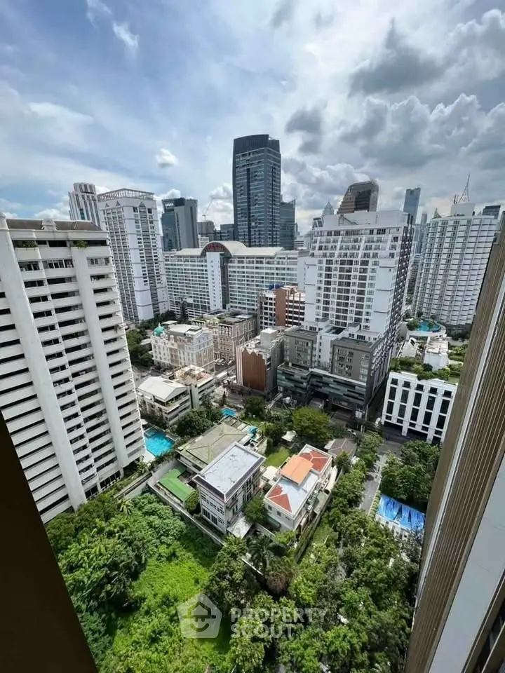 Stunning cityscape view from high-rise building showcasing urban skyline and lush greenery.