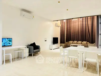 Spacious modern living room with elegant dining area and cozy seating, perfect for family gatherings.