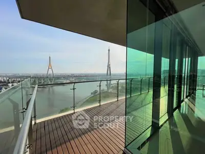 Stunning balcony view with modern glass railing overlooking a scenic river and bridge.