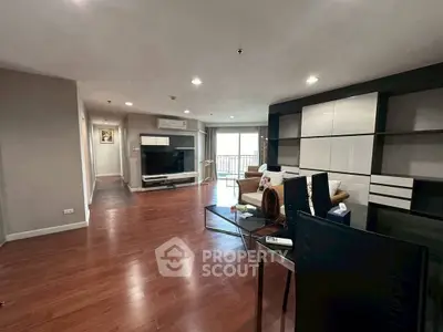 Spacious living room with modern decor and hardwood floors in a stylish apartment.