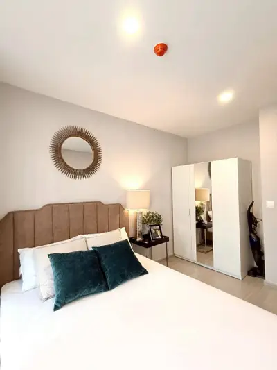 Modern bedroom with stylish decor and mirrored wardrobe