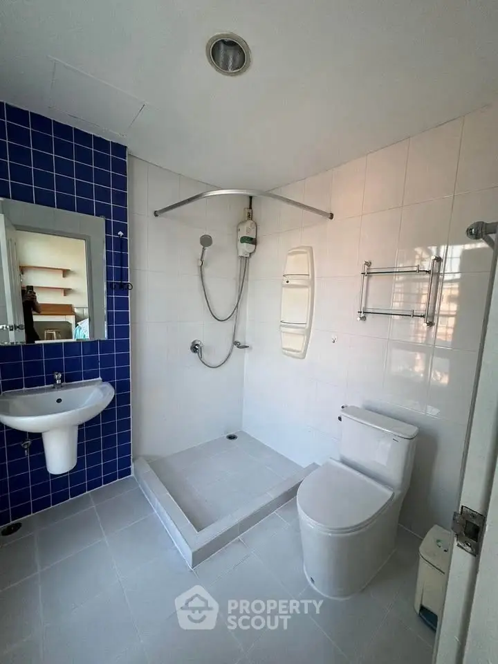 Modern bathroom with blue accent tiles and sleek fixtures