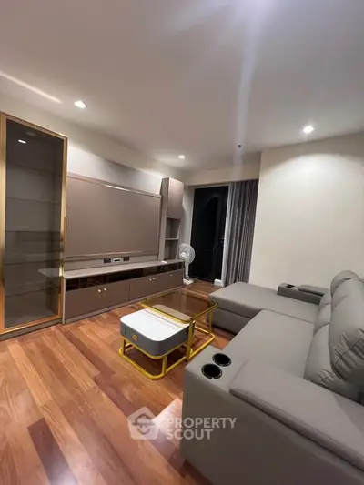 Modern living room with sleek furniture and wooden flooring, perfect for relaxation and entertainment.