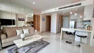 Modern open-plan living room with stylish decor and kitchen area in a luxury apartment.