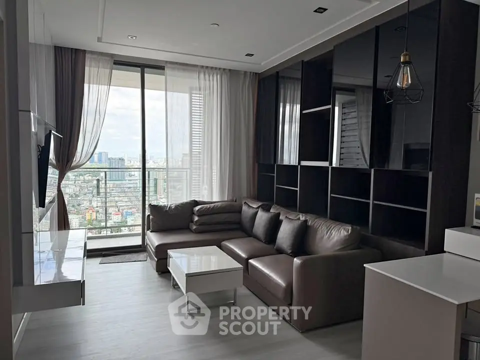 Modern living room with large windows and city view, featuring sleek furniture and stylish decor.