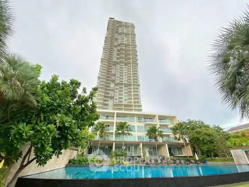 Luxurious high-rise building with pool and lush greenery, perfect for modern living.