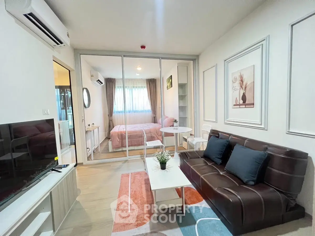Modern studio apartment with stylish decor and glass partition in vibrant city location.