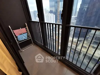 Modern high-rise balcony with cityscape view and drying rack, perfect for urban living.