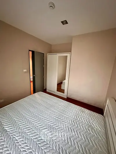 Cozy bedroom with a large wardrobe and comfortable mattress, perfect for relaxation.