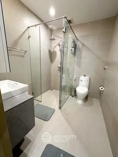 Modern bathroom with glass shower enclosure and sleek fixtures