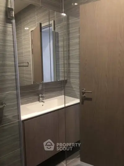 Modern bathroom with sleek vanity and mirror in stylish apartment.