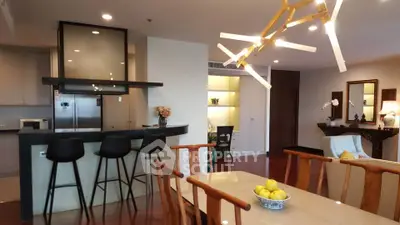 Modern open-plan kitchen and dining area with stylish lighting and sleek design.