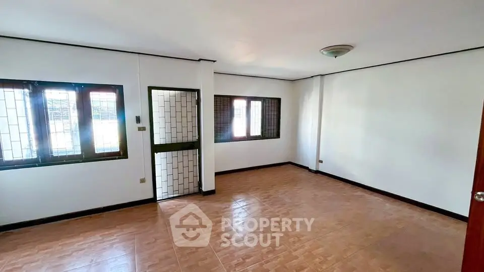 Spacious unfurnished room with tiled flooring and large windows for natural light.