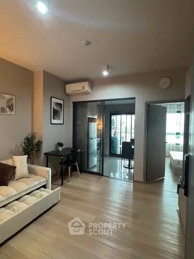 Modern living room with elegant decor and open layout leading to kitchen and bedroom.