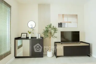Modern living room with stylish decor, TV unit, and indoor plant, perfect for cozy relaxation.