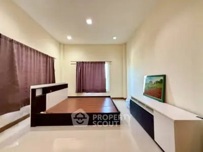 Spacious bedroom with modern design and natural light, featuring elegant curtains and sleek furniture.
