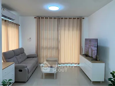 Modern living room with cozy sofa and flat-screen TV, perfect for relaxation.